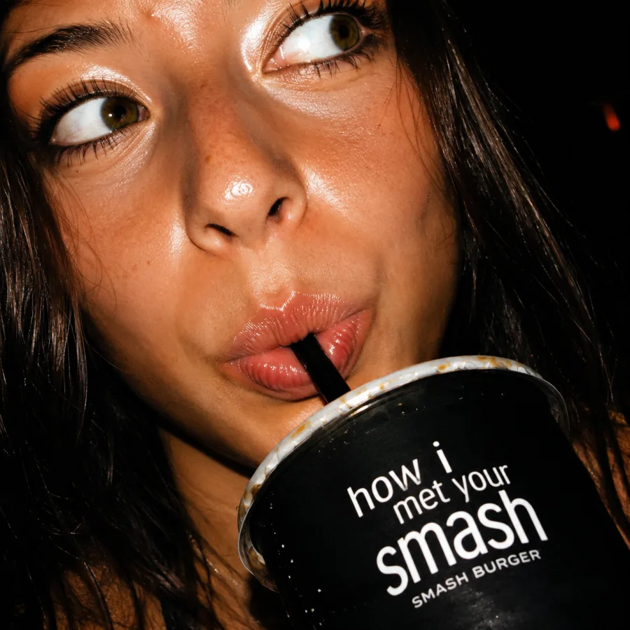 Ragazza che beve con la cannuccia dal bicchiere How I Met Your Smash